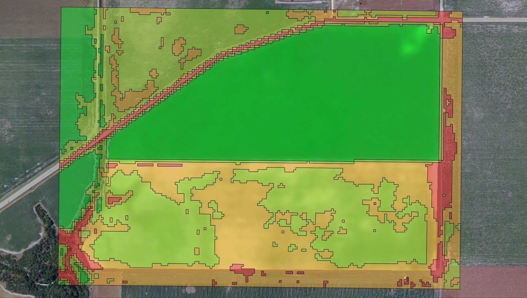 A field split into productivity zones from its vigor data — high-vigor greens through low-vigor reds — the basis for a variable-rate prescription
